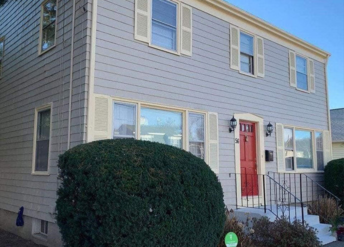 A house with a freshly painted red door and a matching fire hydrant in front of it thanks to Prep Smart Professional Painting's exterior painting services.