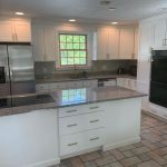 A kitchen with white cabinets and granite counter tops featured in a photo gallery.