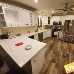 A gallery of a kitchen with white cabinets and stainless steel appliances.