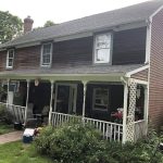 A welcoming house with a charming porch tucked away in the peaceful woods.