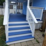 A blue and white porch with white steps showcased in a house painting photo gallery.