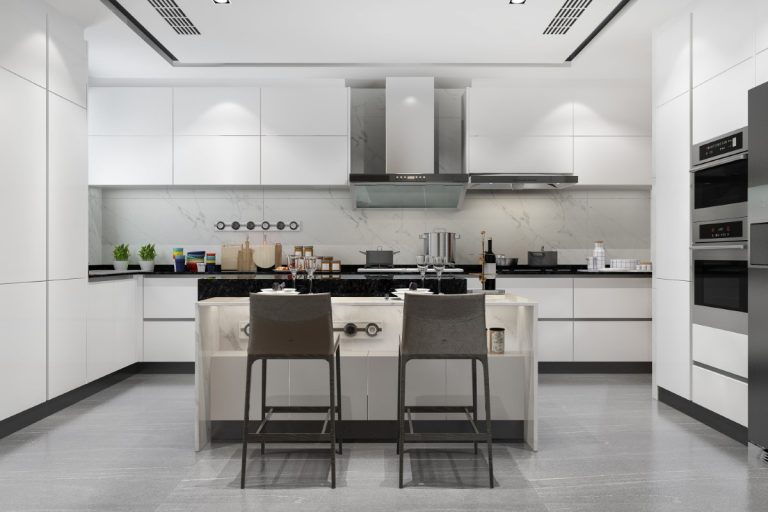 A modern kitchen with white cabinets and stainless steel appliances featuring sleek design elements.