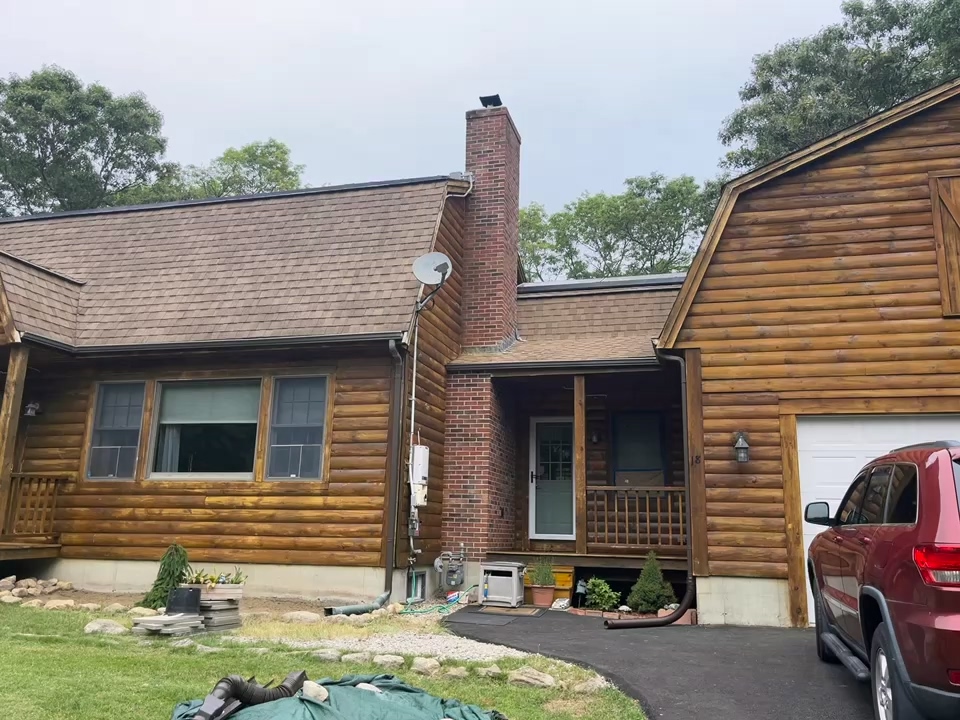 A log cabin with a car parked in front of it.