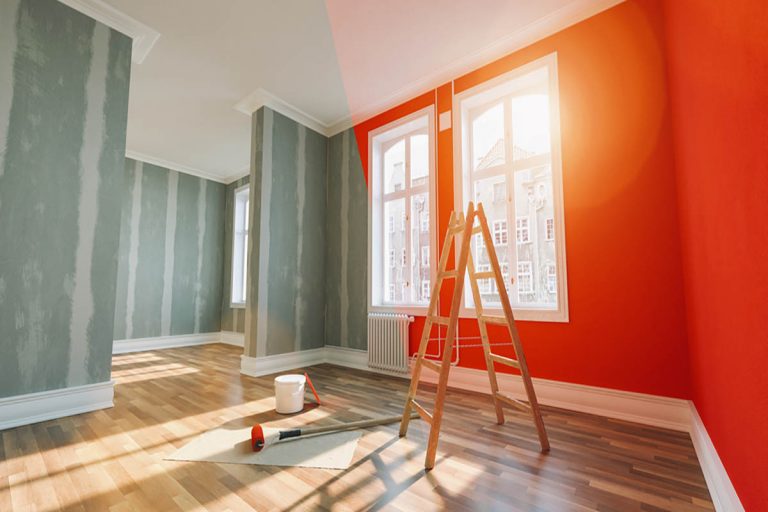 A room with orange walls and a ladder for expert painting advice.