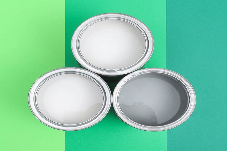 Three cans of paint on a background.