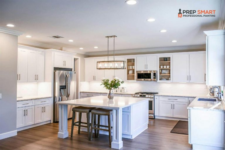 A kitchen with painted white cabinets and a center island