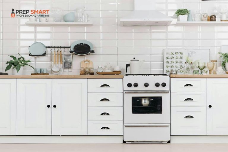 A white kitchen with dark cabinets, a stove and oven.