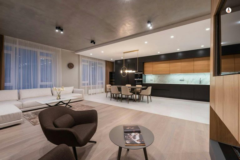 Expansive open concept living and kitchen space with dark painted ceiling white walls black cabinetry and hardwood floors in Rhode Island
