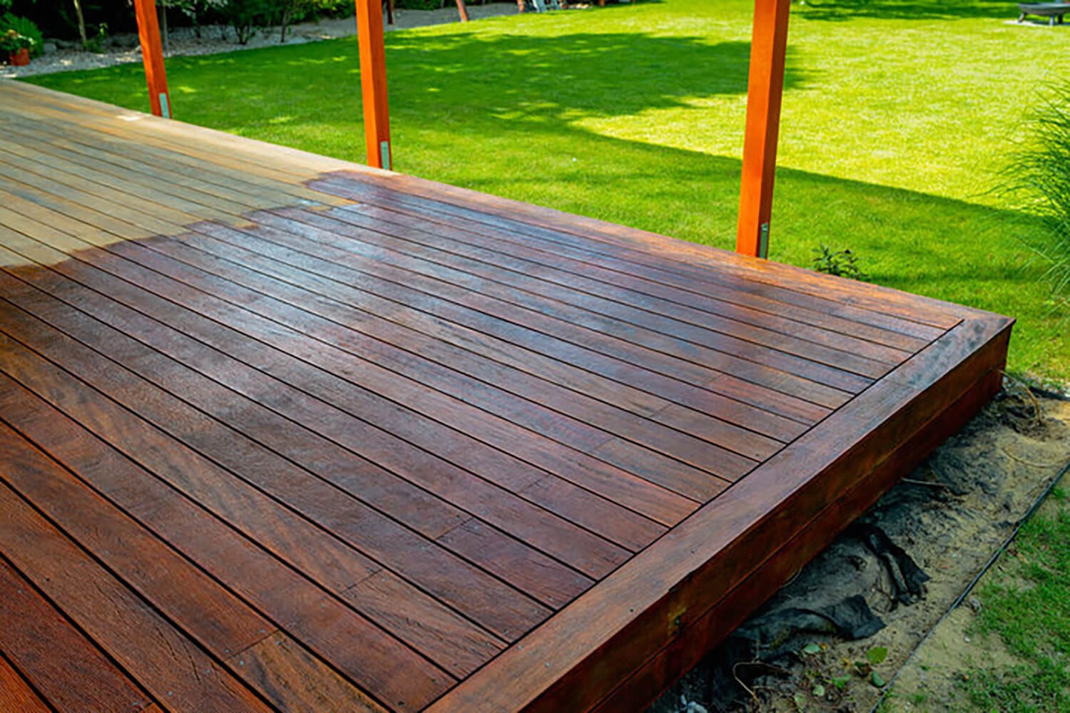 Wood deck with fresh stain and smooth boards, showing signs your deck needs refinishing after winter in Warwick