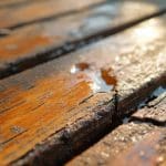 Close-up of cracked and weathered wood deck boards in direct sunlight showing how to protect a deck from sun damage before UV exposure causes further deterioration